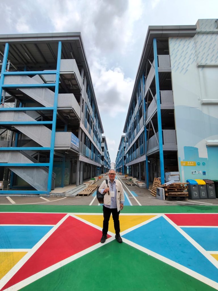 Rusmin Lawin standing on colorful walkway at Kai Tak Development Hong Kong residential area